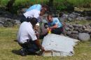 File picture shows French gendarmes and police inspecting a large piece of plane debris which was found on the beach in Saint-Andre on the French Indian Ocean island of La Reunion