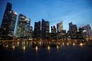People walk past the skyline of Marina Bay central business district in Singapore