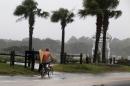 A surfer rides his bike down Atlantic Boulevard during the heavy rains of Tropical Storm Hermine as it passed through Garden City Beach