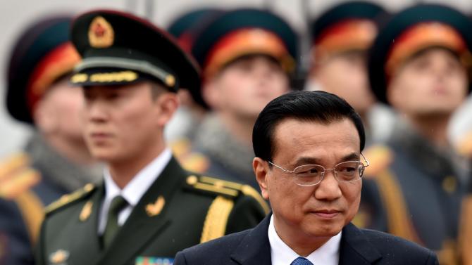 Chinese Prime Minister Li Keqiang reviews a Russian honor guard on October 12, 2014 during an official welcoming ceremony at Vnukovo airport outside Moscow