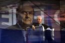 Mario Monti, sullo sfondo una foto di Pier Luigi Bersani.