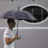 Mercedes Formula One driver Schumacher of Germany walks through the paddock as it rains ahead of the first practice session of the Singapore F1 Grand Prix
