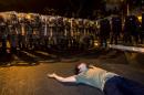 Riot police stand guard as demonstrators hold a demo at Praca da Savassi in Belo Horizonte on June 17, 2014