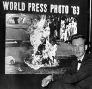FILE - In this Dec. 14, 1963 file photo, Malcolm Browne, Saigon correspondent for the Associated Press, poses in front of his photo of a Vietnamese Buddhist monk's fiery suicide after the image was selected as the world's best news picture of the year at the Seventh World Press Photo contest in The Hague, Netherlands. Browne, acclaimed for his trenchant reporting of the Vietnam War and the famous photo that shocked the Kennedy White House into a critical policy re-evaluation, has died. He was 81. (AP Photo, File)