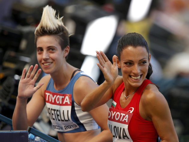 Lalova of Bulgaria leaves the track with Pratelli of San Marino after their women's 100 metres heats during the IAAF World Athletics Championships in Moscow