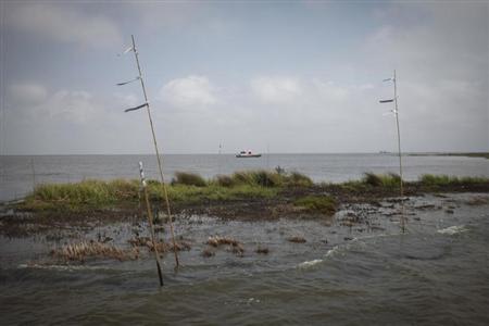 A work boat passes an oiled marshland, one year after the BP Oil Spill, in Bay Jimmy near Myrtle Grove, Louisiana April 20, 2011. REUTERS/Lee Celano
