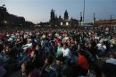 Citizens look to a giant screen during the presidential candidates' televised debate at Zocalo Square in Mexico City