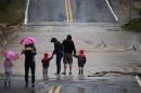 Local residents visit a road which was flooded by Bull Creek after heavy rain in Austin, Texas