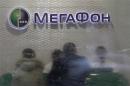 Customers and staff are seen through the partially cleaned window of a Megafon shop in Moscow