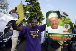 A party supporter holds a poster of the opposition …