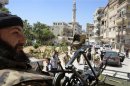 Free Syrian Army fighters escort U.N. vehicles during their visit at one of the sites of an alleged chemical weapons attack in Zamalka