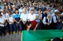 A family member of a victim of a suicide bombing at a wedding celebration mourn over a coffin during a funeral ceremony in the southern Turkish city of Gaziantep
