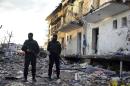 Turkish police officers secure a destroyed police station in Cinar in the mostly-Kurdish Diyarbakir province in southeastern Turkey Thursday, Jan. 14, 2016. Kurdish rebels detonated a car bomb at a police station in southeastern Turkey, then attacked it with rocket launchers and firearms, killing several people, including civilians, the governor's office said Thursday. (Ahmet Un/DHA via AP) TURKEY OUT