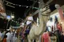 Saudi men, wearing traditional Islamic clothes for the Hajj, ride camels in the al-Alawi market in the old city of Jeddah, Saudi Arabia, January 3, 2006
