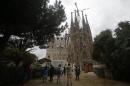 Tourist gather in front of Sagrada Familia church, designed by architect Antoni Gaudi in Barcelona, Spain, Friday, Jan. 27, 2017. Barcelona will curb the number of rooms for visitors in the city center in a controversial move aimed to appease residents concerned about sky-high property prices and opposed by hotel and business owners. (AP Photo/Manu Fernandez)