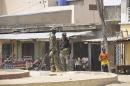 Security forces stand guard at the site of bomb explosion at a market in Maiduguri, Nigeria, Saturday, March 7, 2015 .Two blasts killed more than 10 people on Saturday in a busy marketplace in Maiduguri, the biggest city in northeastern Nigeria, say witnesses. (AP Photo/Jossy Ola)