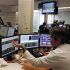 Trader gestures while watching screens in a trading room in Lisbon