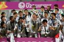 Japan's players celebrate with the trophy following the AFC U23 Championship final football match between Japan and South Korea at Abdullah Bin Khalifa Stadium in Doha on January 30, 2016