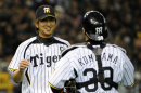 Japan's Hanshin Tigers closer Kyuji Fujikawa (L) is celebrated by catcher Shinji Komiyama (R) after their 5-1 victory against US Major League baseball team Seattle Mariners in the exhibition game in Tokyo on March 25, 2012. Athletics and Mariners are here to participate in the 2012 MLB Opening Series in Japan, March 28 and 29, 2012. AFP PHOTO / TOSHIFUMI KITAMURA (Photo credit should read TOSHIFUMI KITAMURA/AFP/Getty Images)