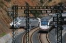 Passenger train passes by wrecked train engine at the site of a train crash in Santiago de Compostela, northwestern Spain
