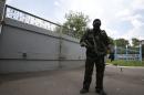 Pro-Russian separatist stands guard near the gates of a base in the east Ukrainian city of Donetsk
