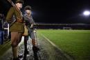 People in military WWI uniforms watch the "Game of Truce", a recreation of a First World War Christmas truce football match, in Aldershot, west of London, on December 17, 2014