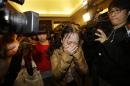 A relative of a passenger of Malaysia Airlines flight MH370 cries as she walks past journalists in Beijing