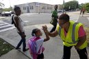 Safety Guard Renee Green high-fives Demari Hill, 5, as she heads to Gresham Elementary School with her parents Destiny and Anthony Hill on her first day of kindergarten classes on Monday, Aug. 26. 2013, in Chicago. Thousands of students will walk newly designated 