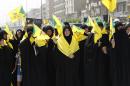 Iraqi Shiite Muslim women wave Iraqi Hezbollah flags