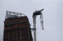 A partially collapsed crane hangs from a high-rise building in Manhattan as Hurricane Sandy makes its approach in New York