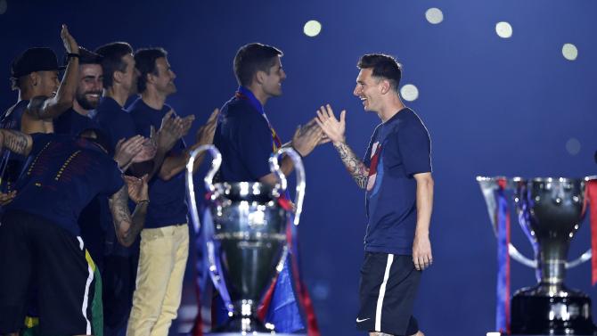 Barcelona&#39;s Lionel Messi, right, celebrates with team mates during celebrations at the Camp Nou stadium in Barcelona, Spain Sunday June 7, 2015 after winning the Champions League final soccer match Saturday by beating Juventus Turin 3-1. Barcelona won the triple this season winning the Spanish League title, the Copa del Rey and the Champions League. (AP Photo/Manu Fernandez)