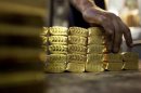A worker grabs pre-cast bars of gold at a plant of refiner and bar manufacturer Argor-Heraeus SA in the southern Swiss town of Mendrisio