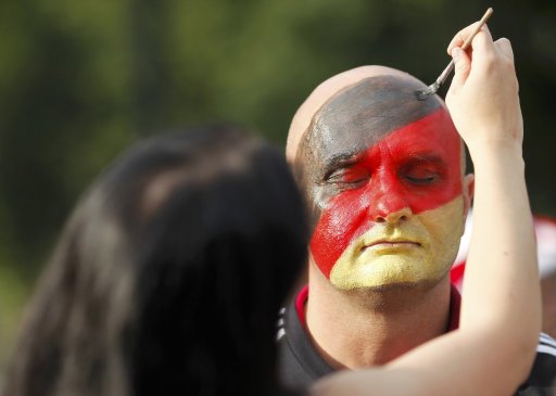 German fans paint their faces on the way to the National stadium to watch the Euro 2012 semi-final match between Germany and Italy in Warsaw