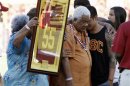 Family members hold up a No. 55 jersey as part of a ceremony held in memory of the late former USC Trojans and NFL linebacker Seau after the first quarter of the NCAA football game between the USC Trojans and the Hawaii Warriors in Los Angeles
