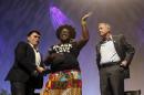 As dozens protesters shout, Tia Oso of the National Coordinator for Black Immigration Network, center, walks up on stage interrupting Democratic presidential candidate, former Maryland Gov. Martin O'Malley, right, as moderator Jose Vargas watches at left, during the Netroots Nation town hall meeting, Saturday, July 18, 2015, in Phoenix. (AP Photo/Ross D. Franklin)