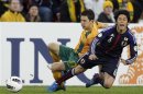 Australia's Matt McKay fights for the ball with Japan's Atsuto Uchida during their 2014 World Cup qualifying soccer match in Brisbane