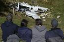 People look at wreckage on September 12, 2015 of a Piper PA-60 Aerostar twin-engine aircraft that crashed the evening before near San Pedro de los Milagros, Colombia