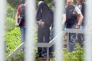 An alleged terror suspect is led by police at the Federal court in Karlsruhe, Germany, Thursday, June 2, 2016. Prosecutors said three Syrian men suspected of planning an attack in Duesseldorf for the Islamic State group have been arrested in Germany. They say a fourth suspect, who informed officials in Paris about the plot, was already in custody in France. (Uli Deck/dpa via AP)