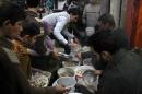 Syrian youths gather to receive aid food in the northern city of Aleppo on January 14, 2014