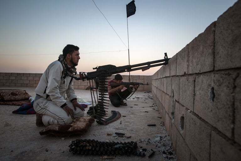 Rebel fighters takes aim at the location of Kurdish fighters in the outskirts of Raqqa, on August 23, 2013