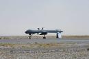 A US Predator drone armed with a missile stands on the tarmac of Kandahar military airport
