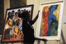 Circle auction organiser Rose Jepkorir displays a painting for the first commercial auction of east African art on November 4, 2013 in Nairobi, on the eve of the the auction