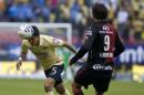 America's Jesus Molina, left, heads for the ball next to Luis Caballero of Atlas during a Mexican soccer league match in Mexico City, Saturday, Nov. 22, 2014. (AP Photo/Christian Palma)