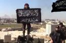 Image grab taken from a video uploaded on YouTube on February 9, 2014 purportedly produced by Jund al-Aqsa, part of the IS bloc, shows one of its fighters holding its unit's flag in a village in Syria's central Hama province