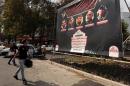 Iranians walk past a banner showing a portrait of Iran's Revolutionary Guards Brigadier General Hossein Hamedani (2nd R) and and two other comrades in Tehran on October 27, 2015