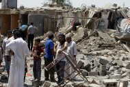 Des Irakiens se tiennent parmi les ruines des maisons touchéees par un attentat à Taji, près de Bagdad, le 23 juillet 2012, Ahmad al-Rubaye afp.com