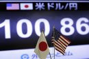 A screen indicates the current exchange rate of the U.S. dollar against Japanese yen behind the both countries' flags at a foreign exchange company in Tokyo, Friday, May 10, 2013.(AP Photo/Itsuo Inouye)