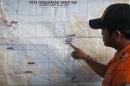 A search and rescue officer points to a co-ordination map of Indonesia at the crisis center set up by local authorities in search of the missing AirAsia flight QZ8501 at Juanda International Airport in Surabaya, East Java, Indonesia, Monday, Dec. 29, 2014. Search planes and ships from several countries on Monday were scouring Indonesian waters over which the AirAsia jet disappeared, more than a day into the region's latest aviation mystery. Flight 8501 vanished Sunday in airspace thick with storm clouds on its way from Surabaya, Indonesia, to Singapore. (AP Photo/Trisnadi Marjan)