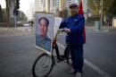 Retired shipyard worker Qiu poses for a photograph with his bicycle bearing a portrait of China's late Chairman Mao Zedong on a street in Shanghai