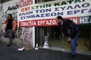 Employees of the Athens-Piraeus Electric Railway block the entrance of the company headquarters in Athens